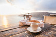 © kite_rin - Mediterranean breakfast, cup of coffee and fresh bread on a table with beautiful sea view at the background
