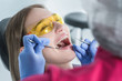 © Валентина Баранова - A dentist examines a patient, close-up of a patient with an open mouth next to which dental objects
