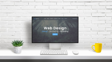 Wall Mural - web design studio concept with computer display and web design agency web page. clean desk with plan