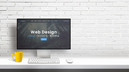 Fototapete - Web design studio computer display with agency portfolio web page. Copy space beside on white brick wall