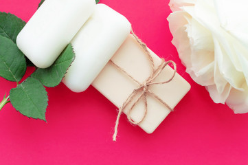 the soap is tied with a rope and a white rose on a pink background with a place for the inscription. Concept of hygiene and Spa procedures.