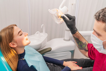 Wall Mural - dentist illuminates the patient mouth