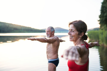 Sticker - Senior couple in swimsuit standing in lake outdoors before swimming.