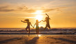 © Global News Art - Silhouette of three beautiful women having fun running and jumping on a beach at sunset or sunrise.