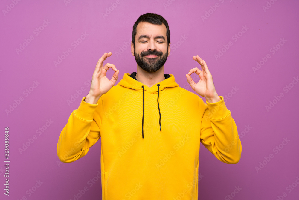 Handsome man with yellow sweatshirt in zen pose - obrazy, fototapety, plakaty 