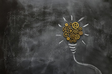 Wall Mural - Education concept image. Creative idea and innovation. Vintage gears light bulb metaphor over blackboard