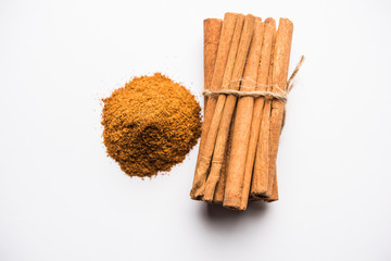 Wall Mural - Powder cinnamon and sticks also known as Dalchini or Dalcheenee masala from India, selective focus