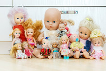 Many Dolls Sits On Floor In Nursery, Playroom. Lot Of Toys In Children's Room