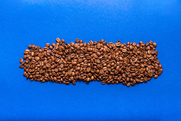 Coffee beans on a blue background. Copy space