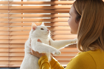 Canvas Print - Young woman with her beautiful white cat near window at home. Fluffy pet