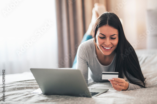 Fotomural Girl using her credit card for online shopping.