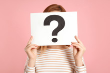 Woman Holding Question Mark Sign On Pink Background
