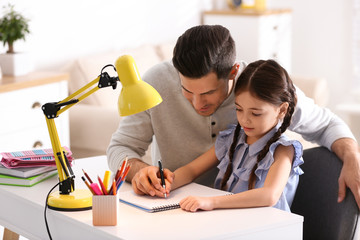 Poster - Man helping his daughter with homework at table indoors