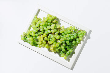 Fresh ripe green grapes in a white frame