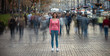 The young girl stands on the crowded urban street
