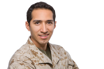 Close up of a Marine in uniform smiling at the camera on a white background.