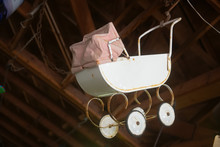 Retro Style Pram. Baby Carriage Of The Last Century Hanging Under The Roof