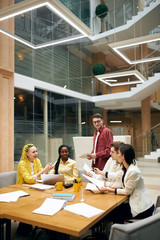 stylish woman in yellow suit and dreads presenting the goods to colleagues, advertising product, advertisement. managers discussing strategy of development of company