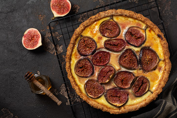 Wall Mural - Homemade quiche tart with figs, cream cheese and honey on dark brown background. Vintage style. Top view.