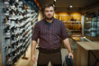 © Nomad_Soul - Man in hunting uniform holds ammo belt in gun shop