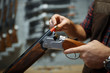 © Nomad_Soul - Man loads a rifle, gun shop interior on background