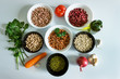 © 008melisa - Set of products for making a recipe from legumes: phaseolus; beans; chickpeas; mung beans; tomatoes, onions, olive oil, carrots, garlic and herbs.