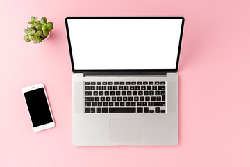 Business background with laptop with empty screen and accessories on pink table. Office desktop. Top view