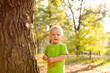 © justesfir - Cute little boy smiling near tree in summer