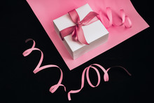 Present Boxes With Pink Ribbon On The Pink And Black Background