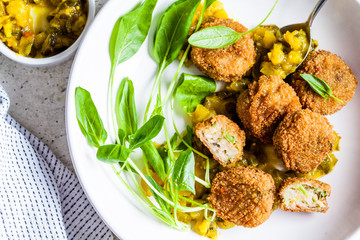 Vegan vegetable meatballs with spinach and green dressing, top view.