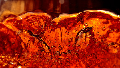 Alcoholic drink on a dark background, abstract splashing.