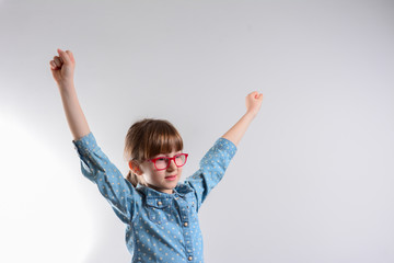 Wall Mural - Young beautiful happy girl portrait isolated on gray. Young smiling girl holding hands up, looking at camera.