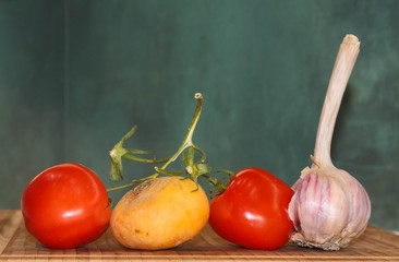 Two tomatoes with ponytails along with turnips and garlic cooked for salad