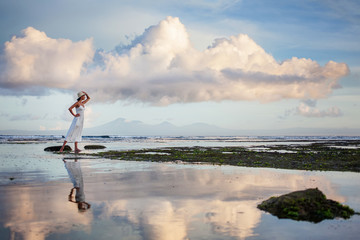 Wall Mural - Beautiful woman by the ocean at sunset