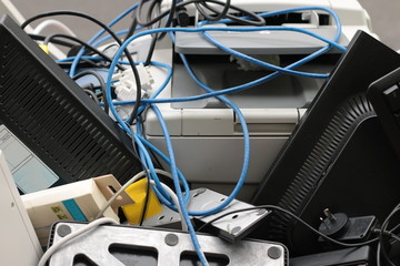 a pile of plastic technology waste and used broken office equipment heaped in a rubbish bin being taken for disposal