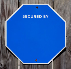 Wall Mural - Blank blue octagonal security sign mounted on fence. Copy space.