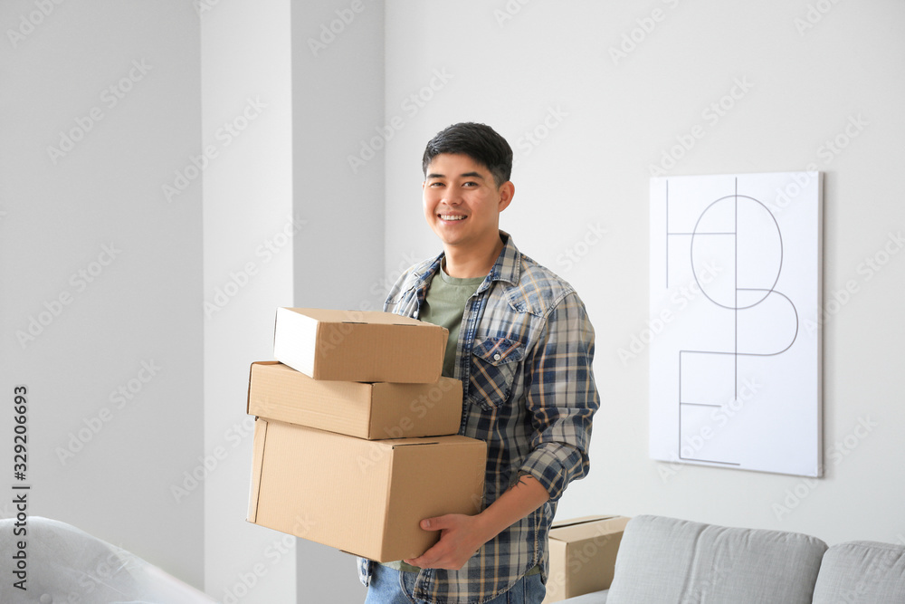 Asian man with belongings at home on moving day