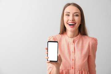 Sticker - Young woman with mobile phone on light background