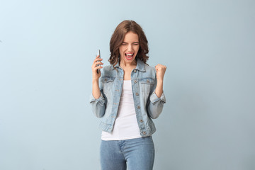 Sticker - Happy young woman with mobile phone on color background