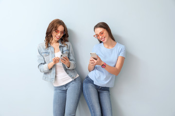 Sticker - Young women with mobile phones on color background