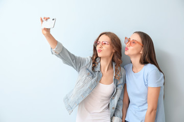 Sticker - Young women taking selfie on color background