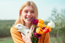Easter Bunny. Beautiful Young Woman With Bunny Rabbit On Farm.