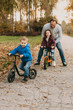 © Strelciuc - Caucasian father is teaching his kids to ride the bike during an autumn walk