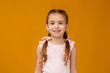 © producer - Cute smiling little child girl looking to camera on pink background. Human emotions and facial expression