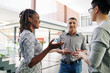 © DragonImages - Cheerful business people actively gesturing when discussing important issues at office hall