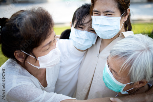 Sad asian family wearing medical mask crying,suffer from grief,great loss of her family infected,fight the Covid-19,Coronavirus outbreak,people affected epidemic crisis ,hug,comforting,encouragement