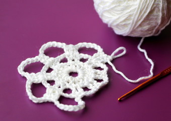 Wall Mural -  White crocheted doily on a purple background. The pattern is created from white cotton threads.