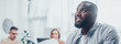 © LIGHTFIELD STUDIOS - panoramic shot of smiling african american and colleagues on background