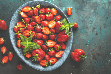 Fresh strawberries in a bowl on wooden table 