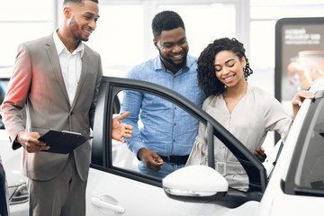 Wall Mural - Car Selling Manager Showing Luxury Car To Buyers In Dealership